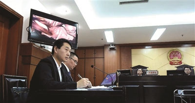 被罚司机陈超(左)在法庭上.新华网图