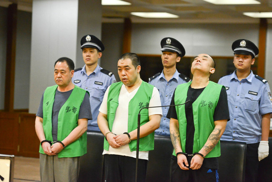 图为梁达(右)和两名同案在法庭听审.