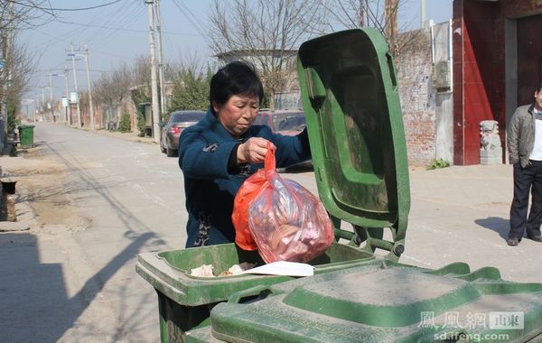 村民将垃圾扔进垃圾箱.