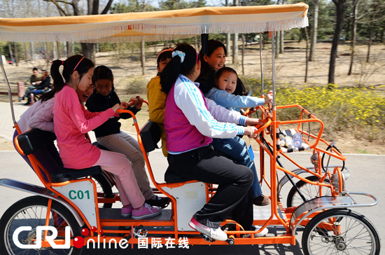 家长和孩子们欢乐骑着多人自行车