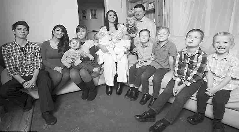 塔妮娅怀抱8个月大的双胞胎,与丈夫和另外9个孩子合照全家福